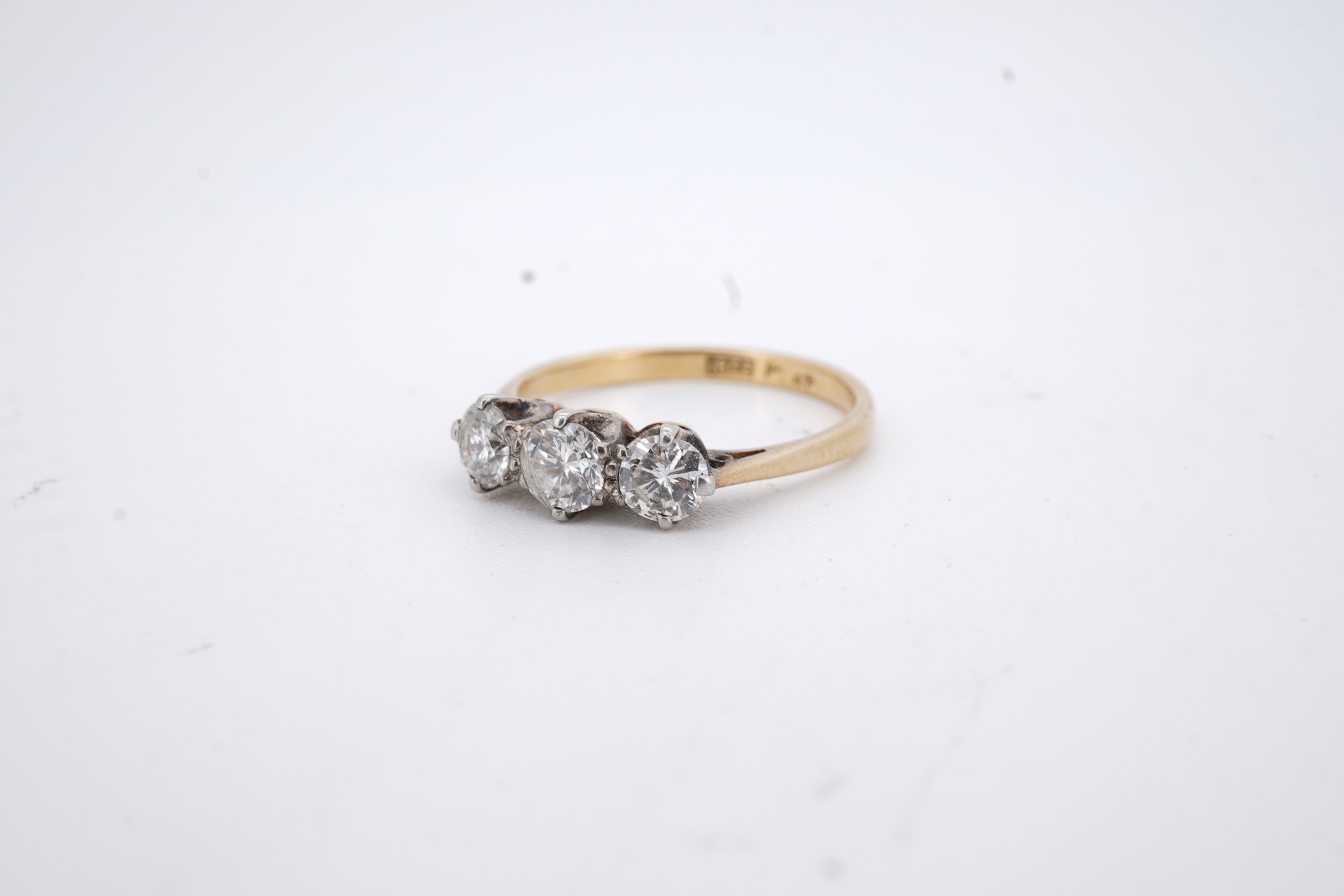 A yellow metal (stamped 18ct, & plat) and three stone diamond set ring, size L, gross weight 2.1 grams.